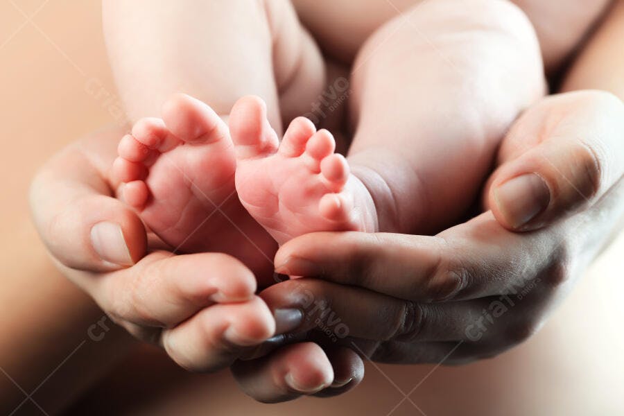 Pés de bebê recém-nascido em mãos amorosas