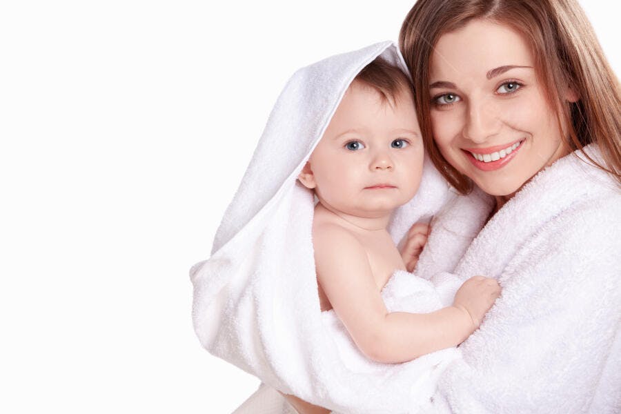 Bebê e mãe em toalhas brancas