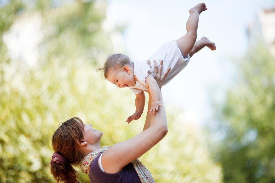 Mãe brincando com bebê ao ar livre