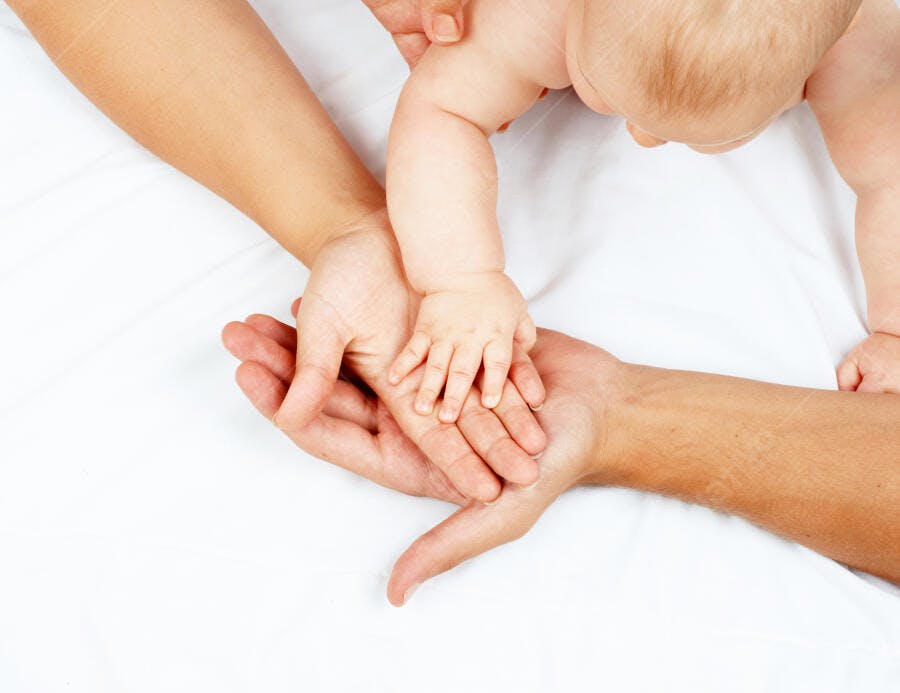 Mãos de pais e bebê unidas