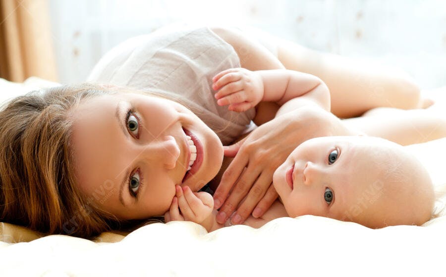 Mãe e Bebê sorrindo na cama
