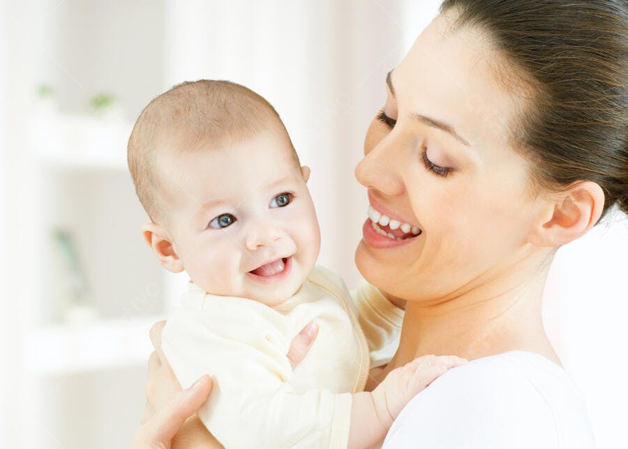 Mãe e bebê sorrindo juntos em casa