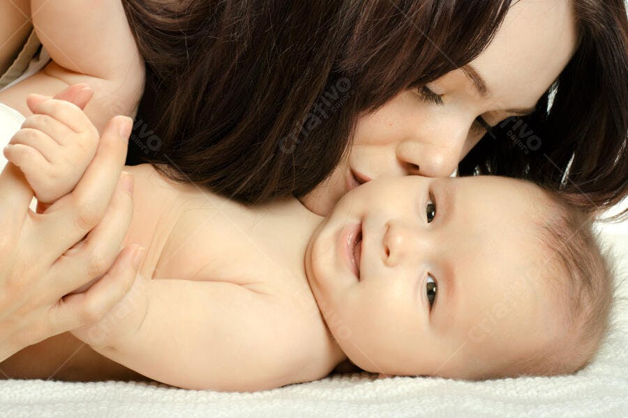 Mãe beijando bebê recém-nascido