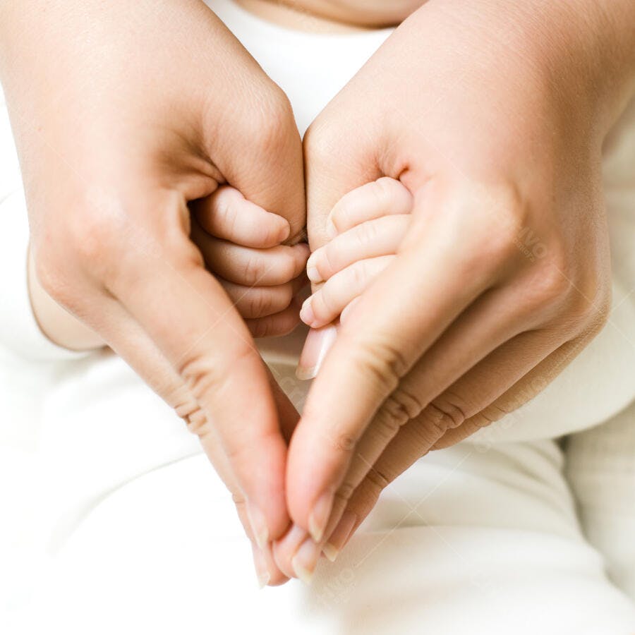 Mãos formando coração com bebê recém-nascido