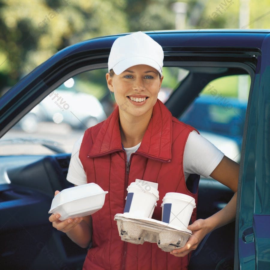 Entregadora sorridente com comida e bebida