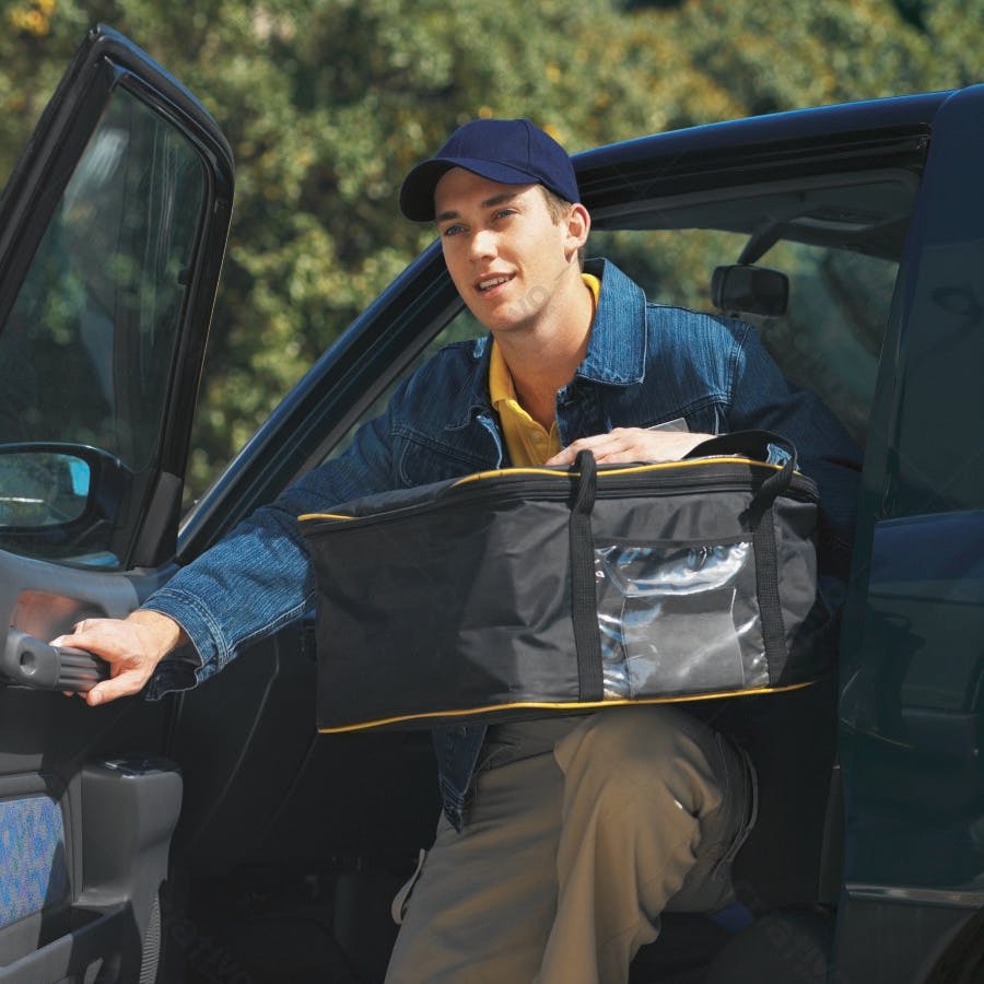 Entregador saindo do carro com mochila térmica