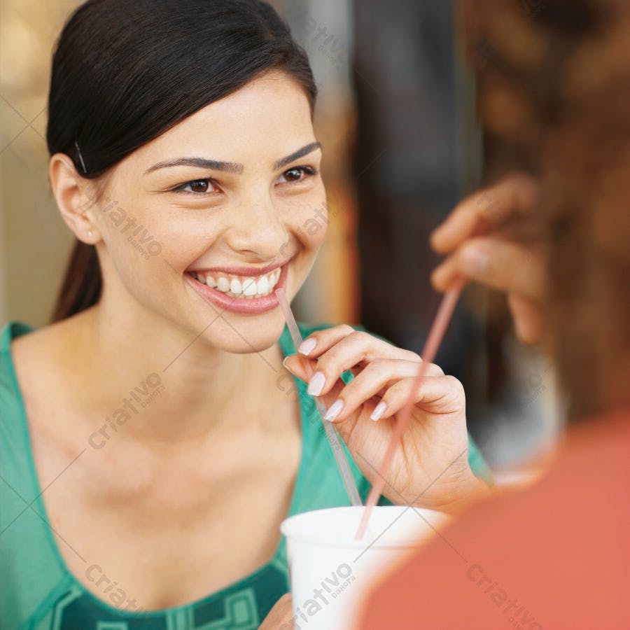 Mulher sorrindo tomando refrigerante com amiga