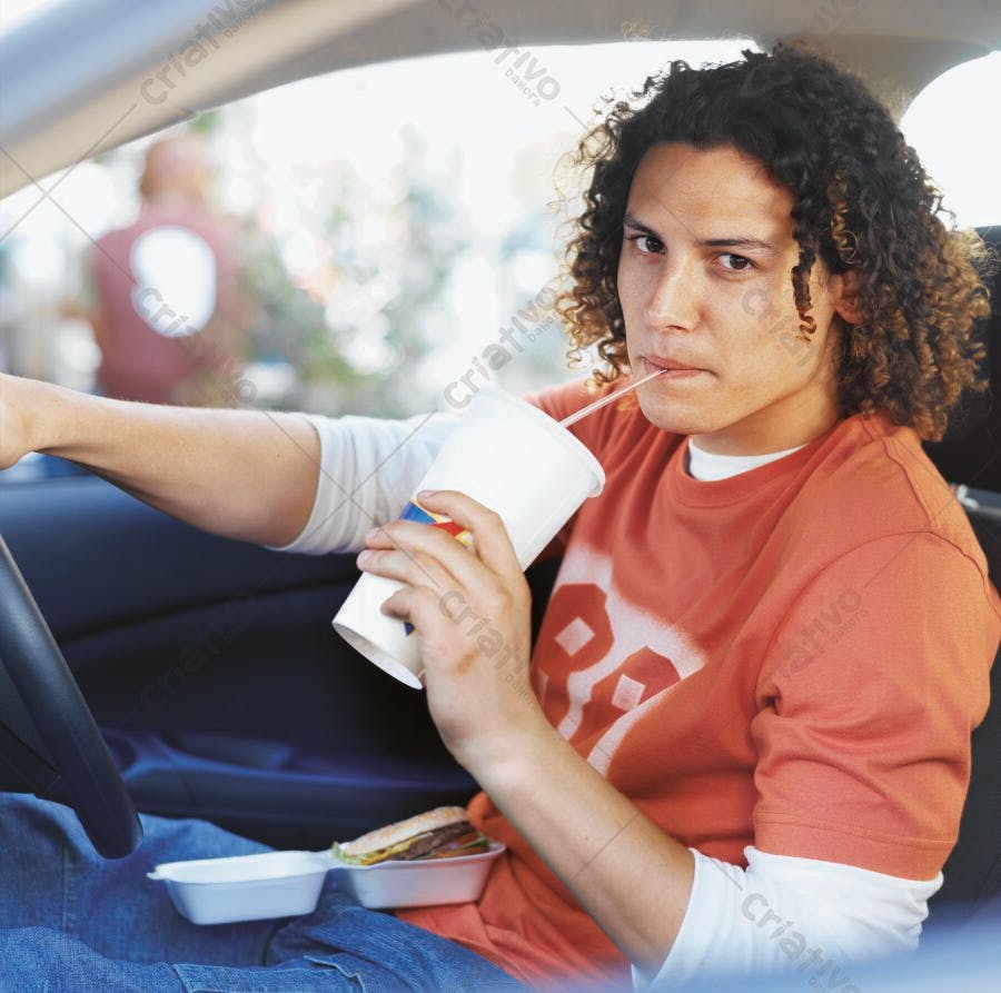 Homem jovem bebendo refrigerante no carro