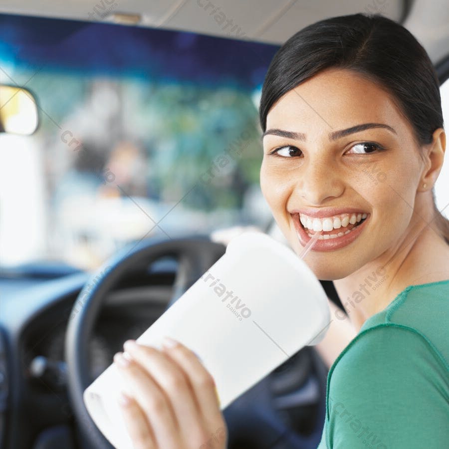 Mulher sorrindo tomando refrigerante no carro