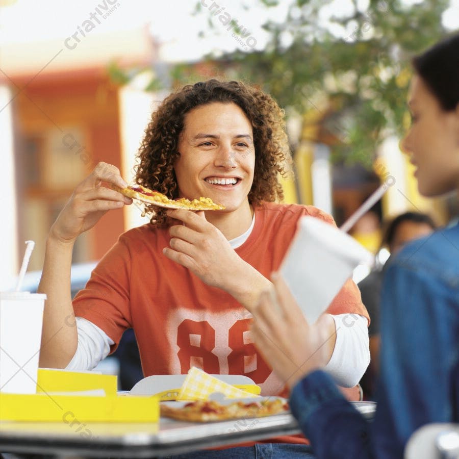 Homem comendo pizza sorrindo ao ar livre