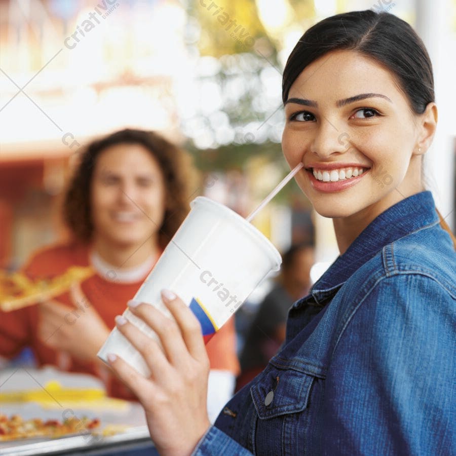 Mulher sorrindo tomando refrigerante em lanchonete