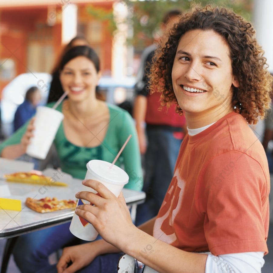 Jovens amigos sorrindo com refrigerantes e pizza