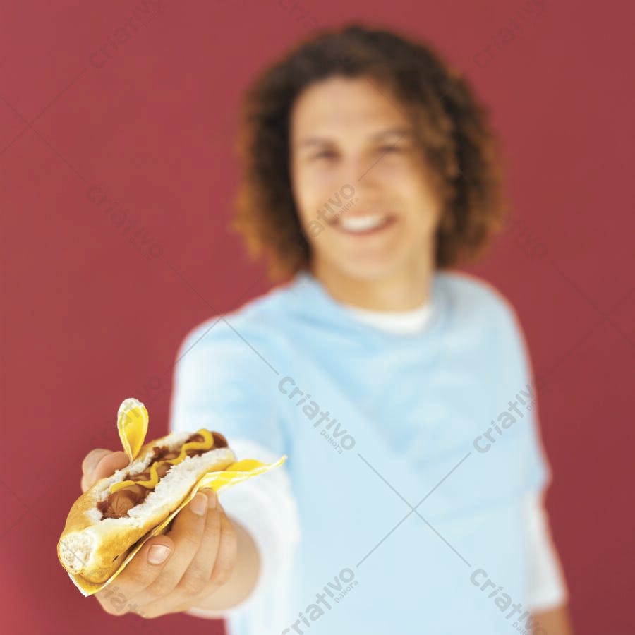 Hot dog com mostarda na mão sorrindo