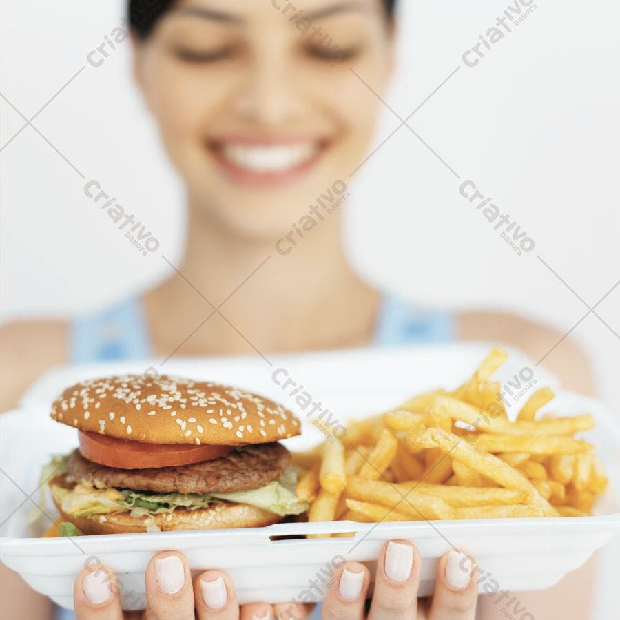 Mulher segura hambúrguer e batatas fritas