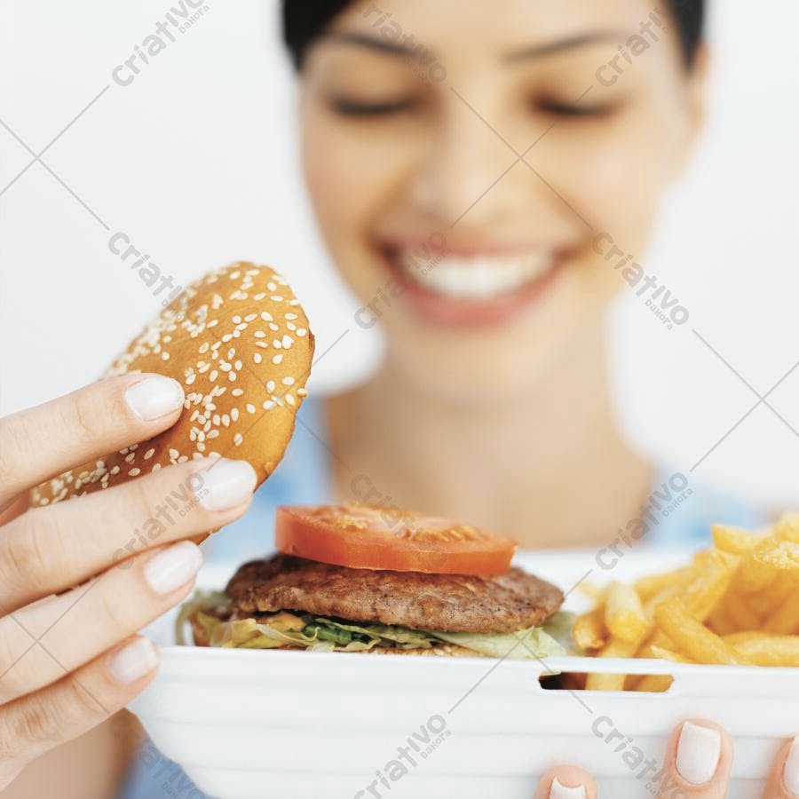 Mulher sorrindo com hambúrguer e batatas