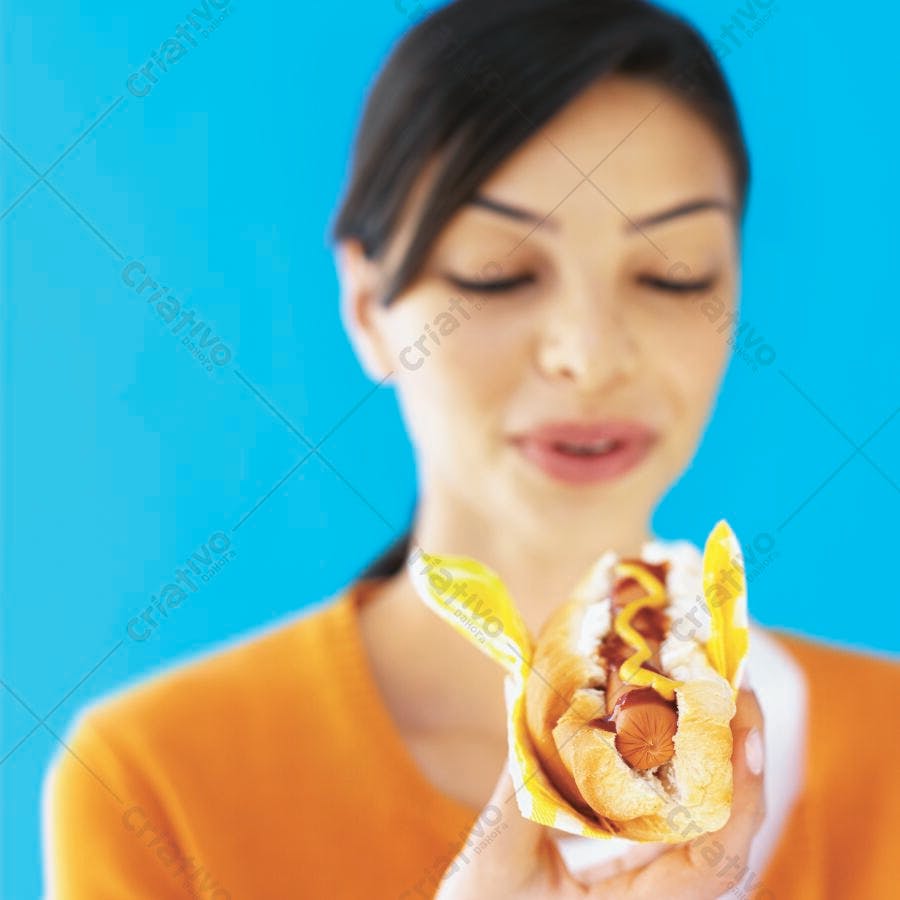 Mulher apreciando cachorro-quente com mostarda