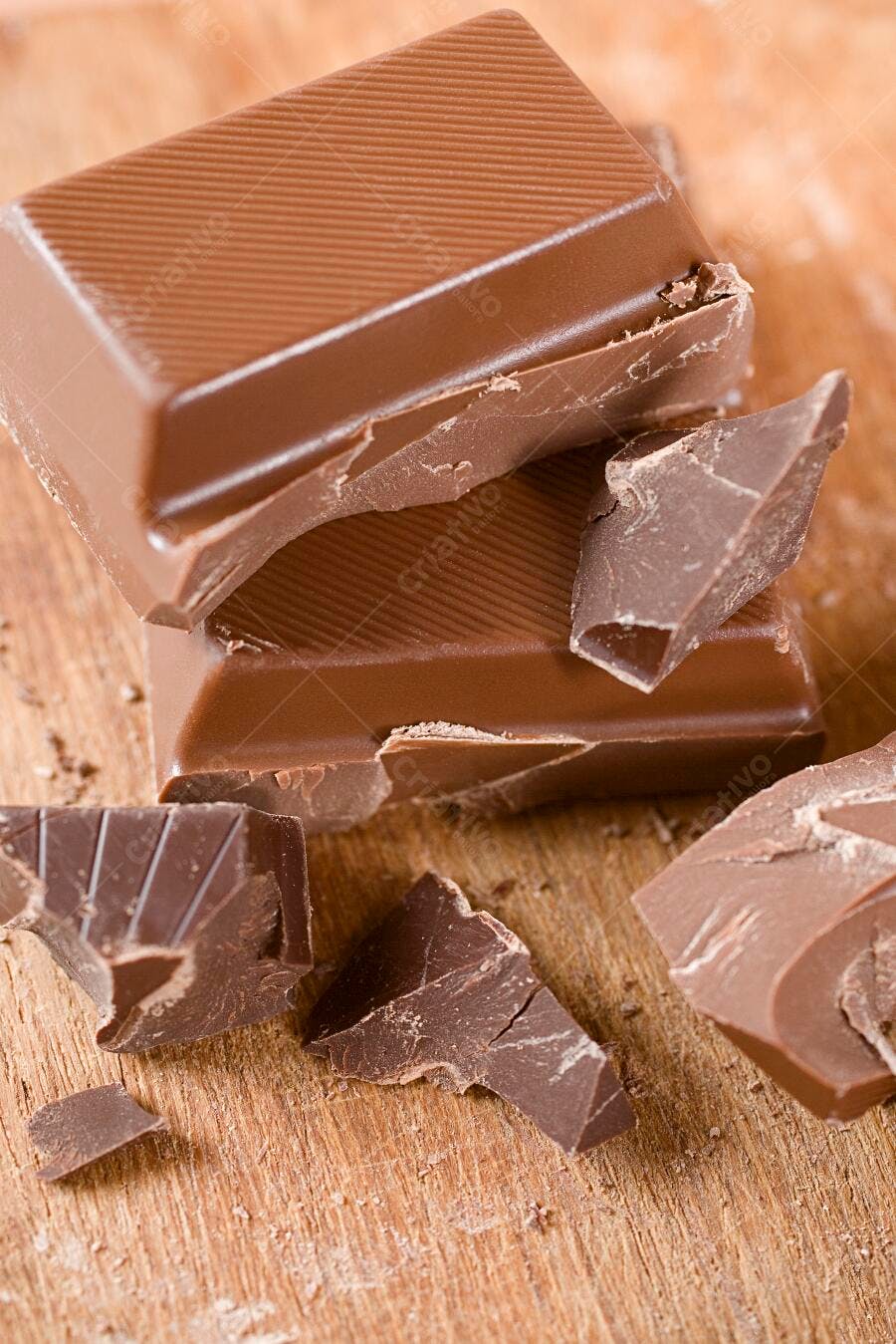 Chocolate amargo em pedaços sobre madeira