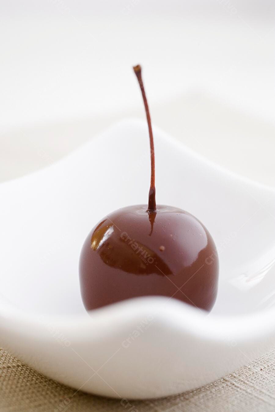 Cereja banhada em chocolate em recipiente branco