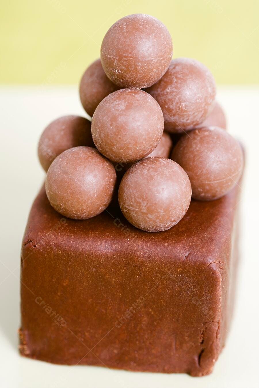 Bombons de chocolate em pirâmide sobre base de chocolate