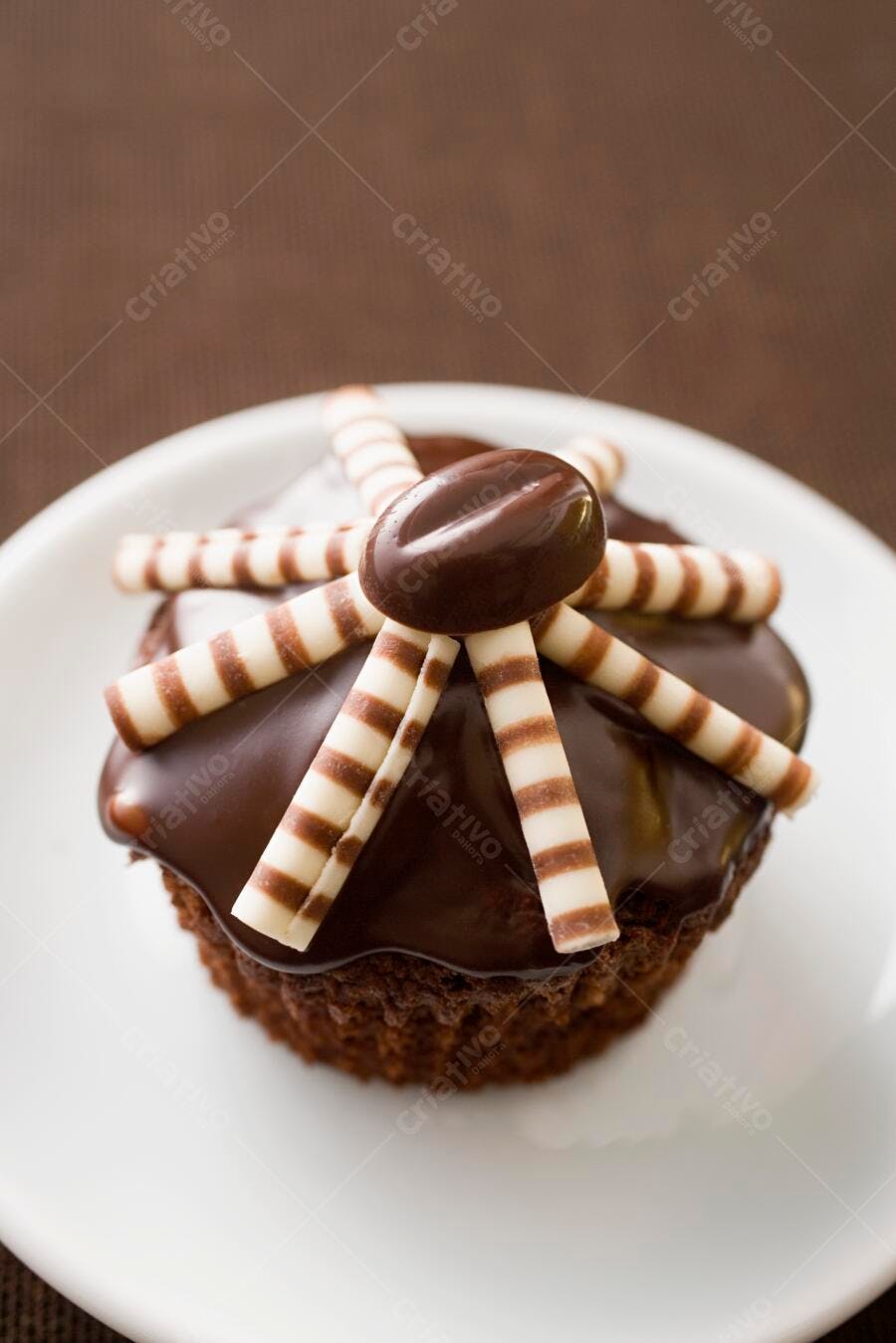 Cupcake de chocolate com cobertura e palitos