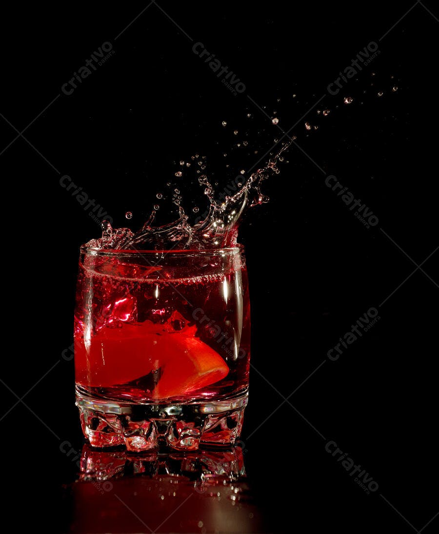 Drink vermelho em copo com respingos