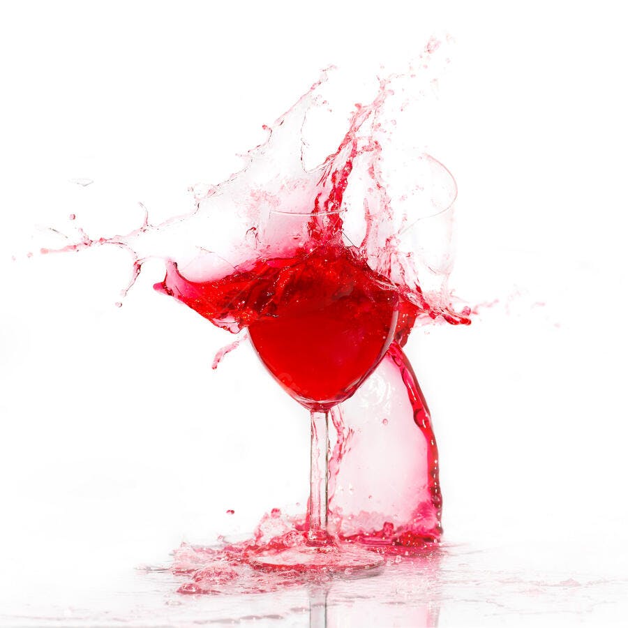 Vinho tinto em copo se derramando