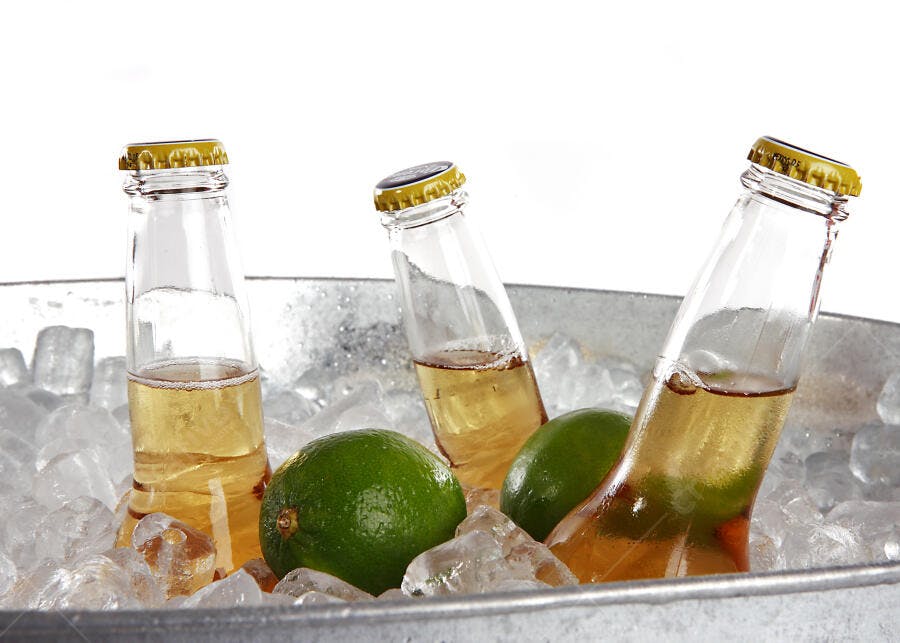 Cervejas geladas com limões em balde de gelo