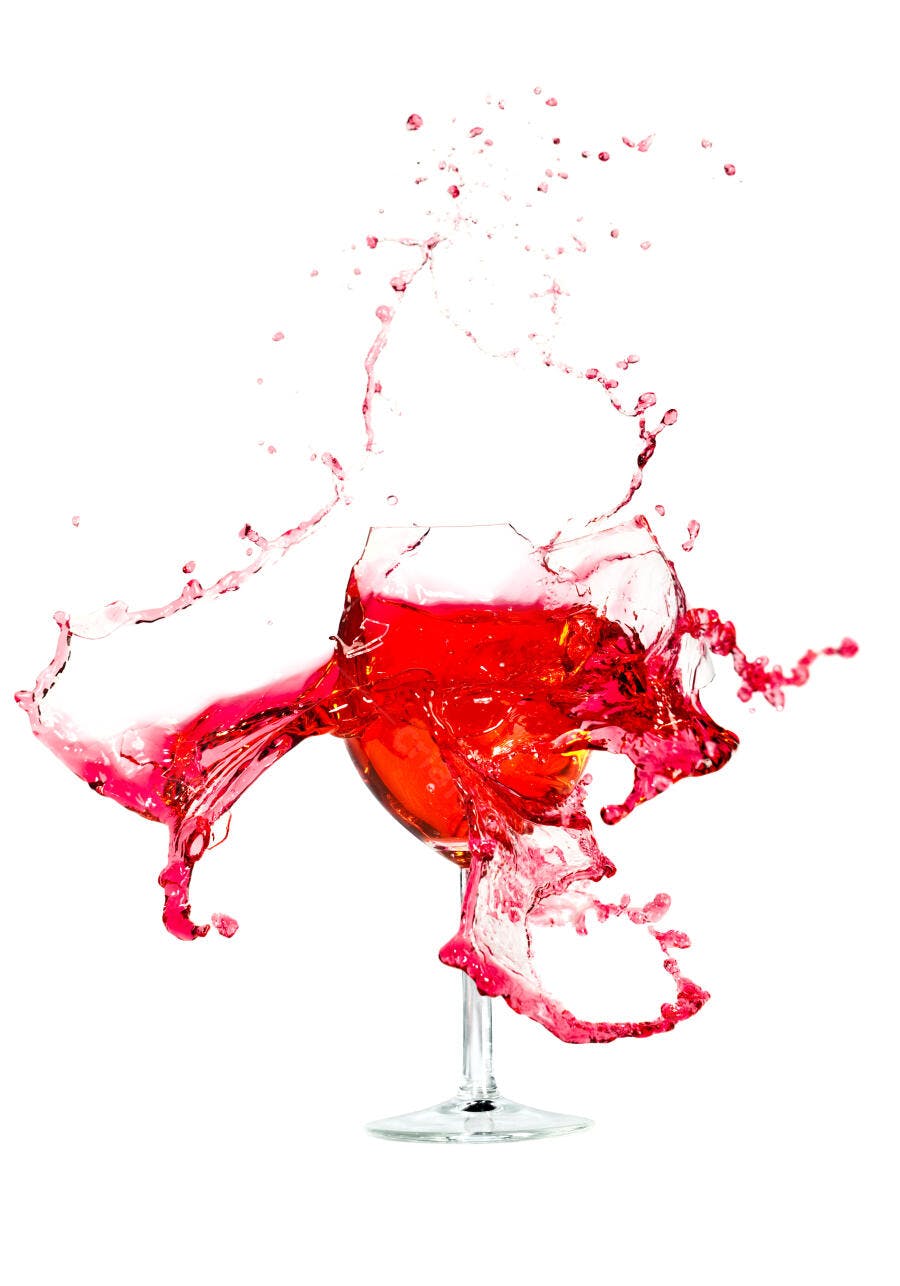 Vinho tinto em taça com respingos