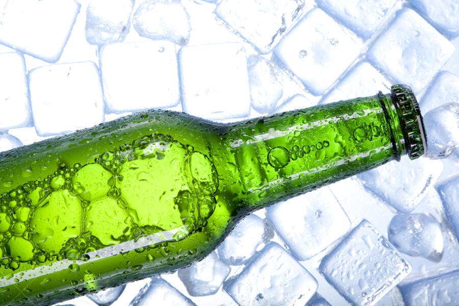 Garrafa de cerveja verde gelada em gelo