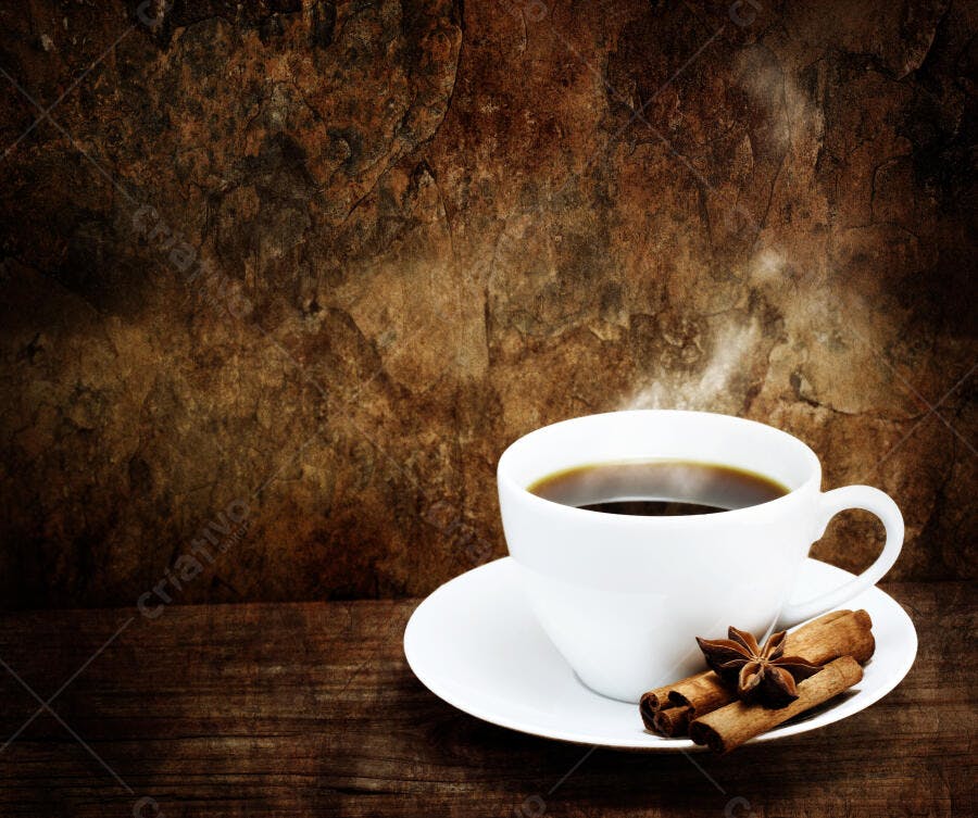 Xícara de café fumegante com canela e anis estrelado
