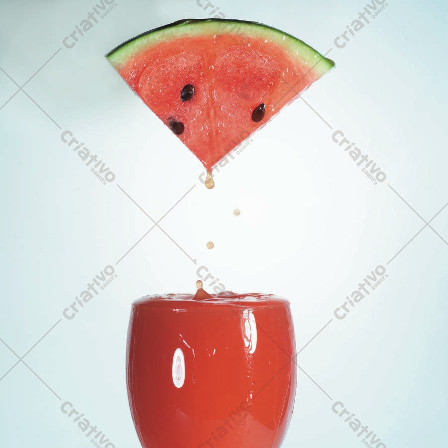 Fatia de melancia caindo em copo suco