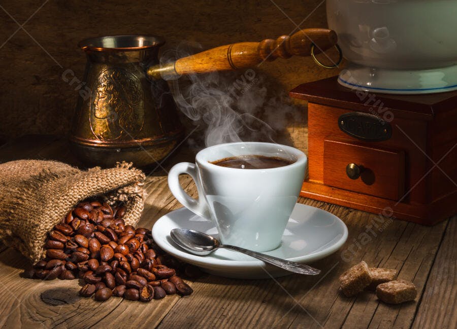 Xícara de café fumegante com grãos e moedor