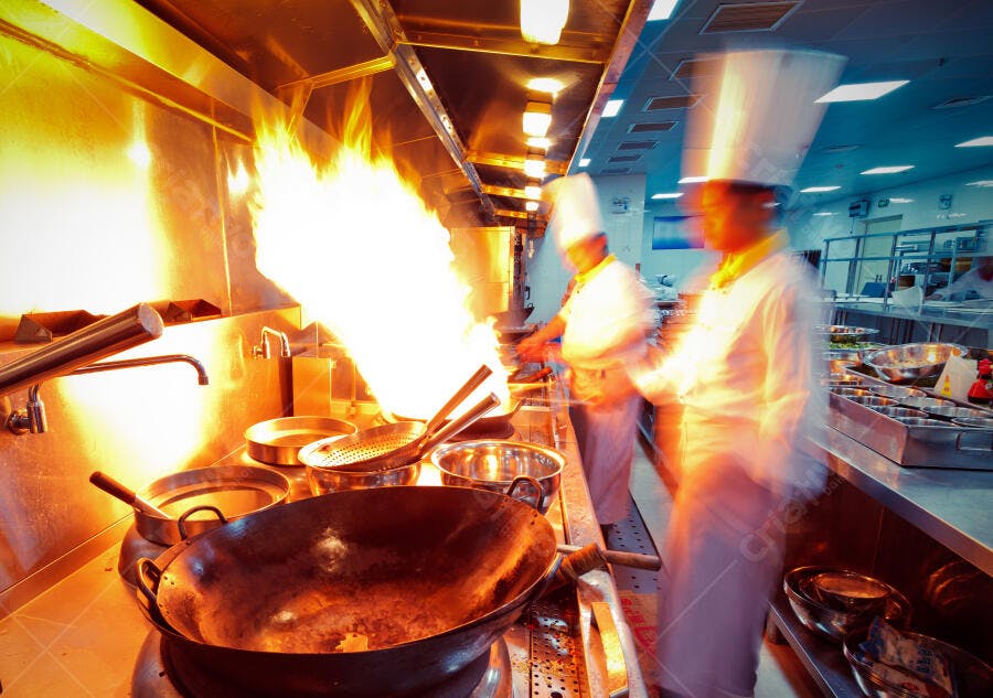 Cozinheiros em ação com chamas na cozinha