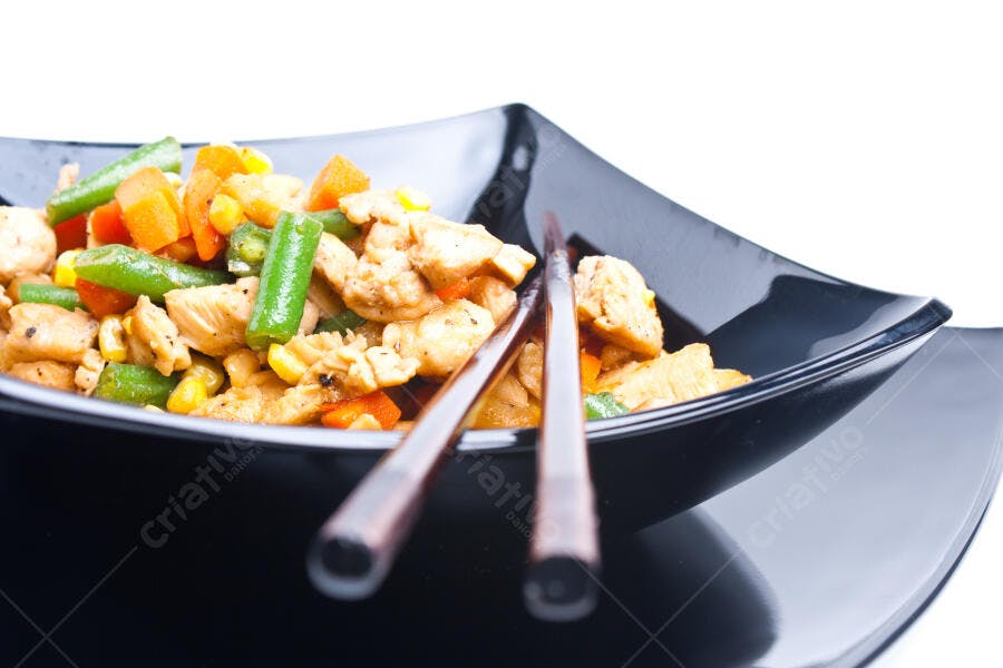Frango com legumes e milho em tigela preta