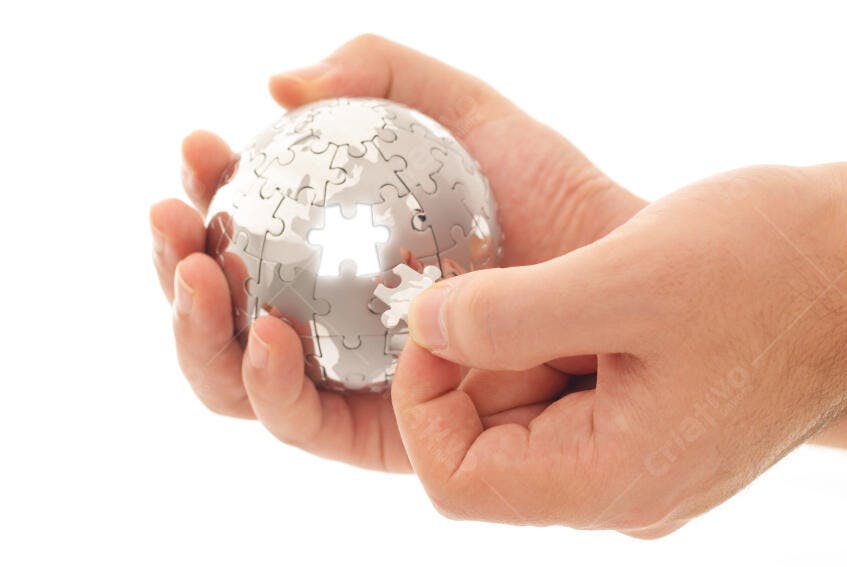 Mãos montando quebra-cabeça globo metálico