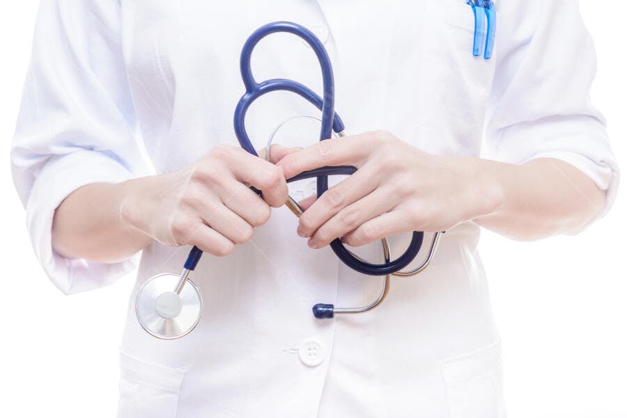 Médica segurando estetoscópio azul