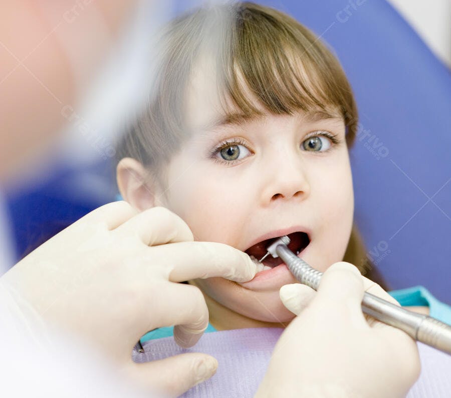 Menina pequena no dentista com instrumento