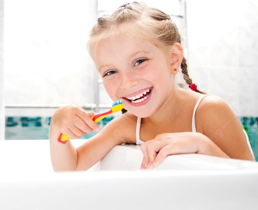 Menina feliz escovando os dentes no banheiro