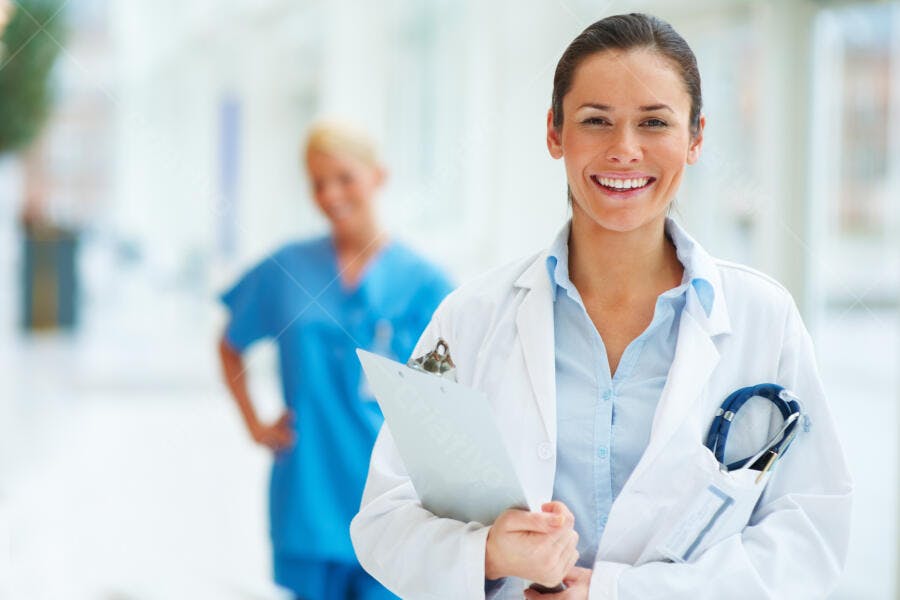 Médica sorridente com prancheta em hospital