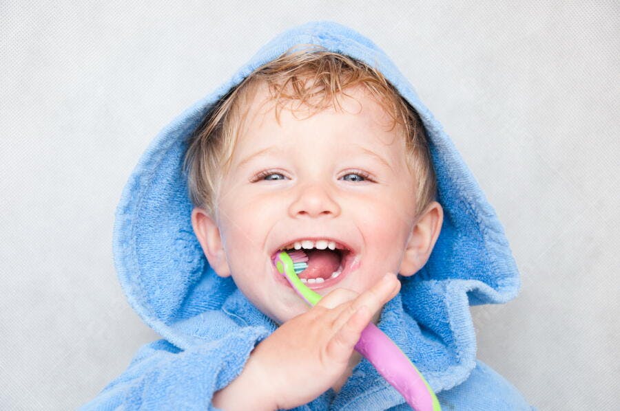 Criança feliz escovando os dentes