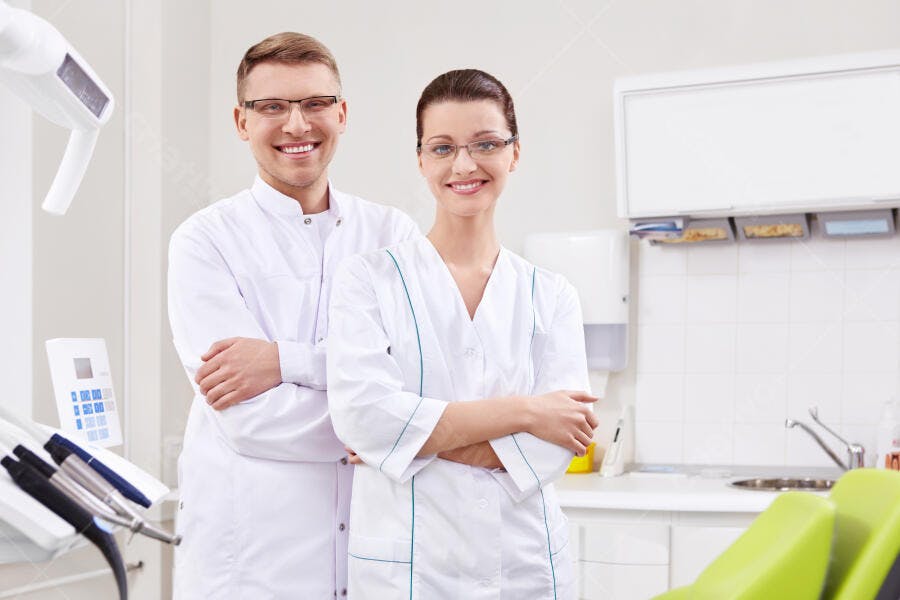 Dentistas sorrindo em consultório moderno