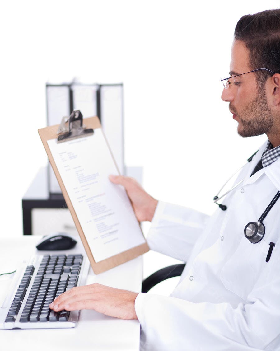 Médico revisando prontuário em consultório