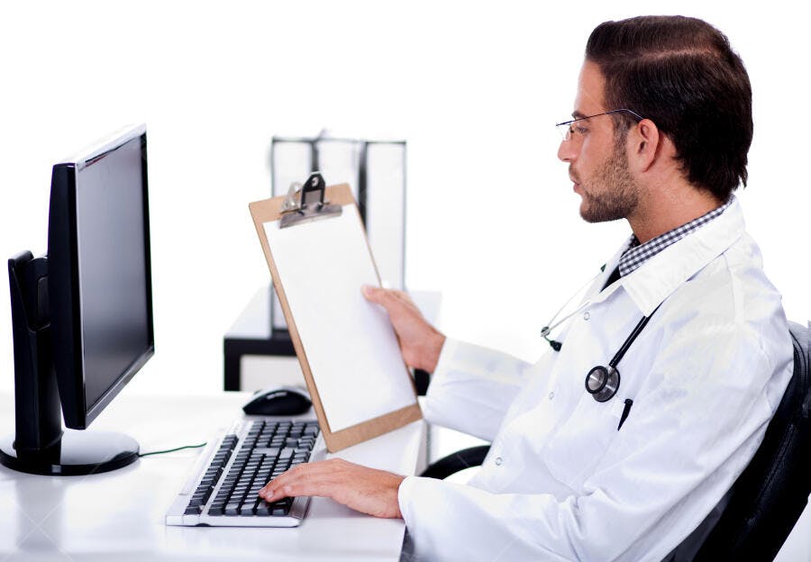 Médico analisando prontuário no computador