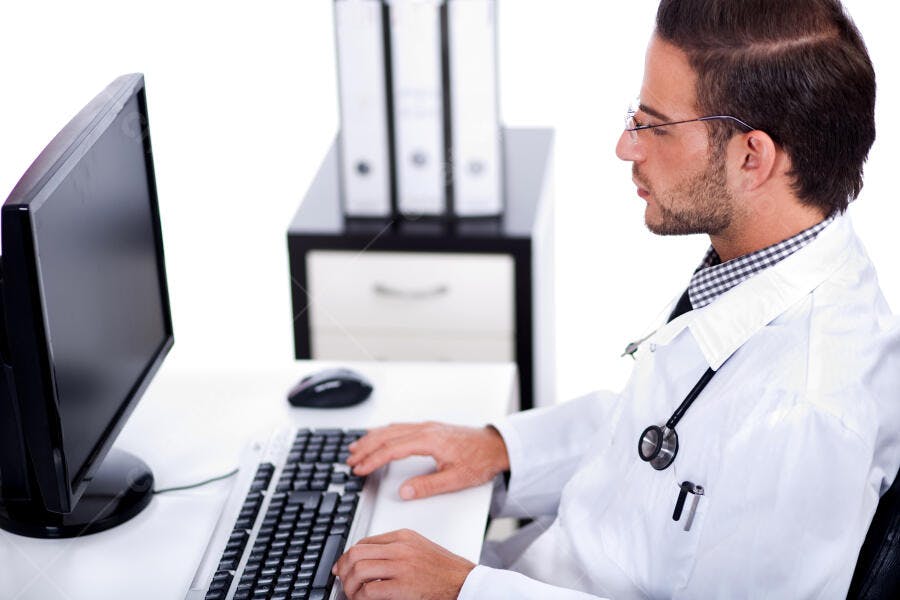 Médico usando computador no consultório