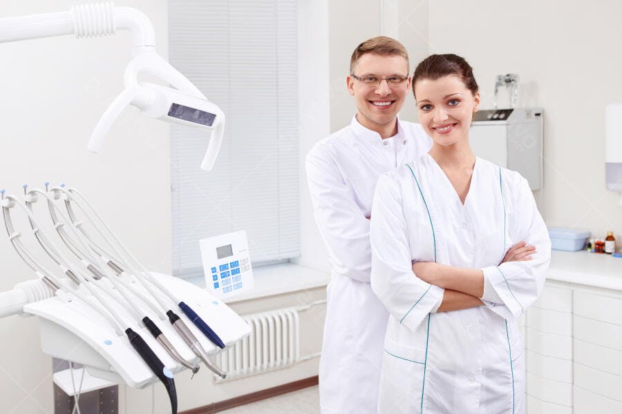Dentistas sorrindo em consultório moderno