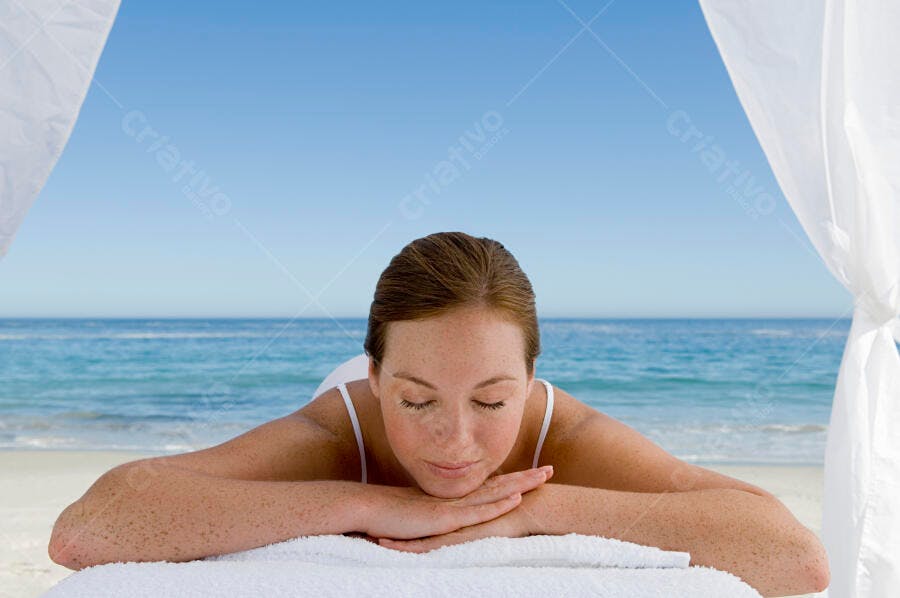 Mulher relaxada em massagem na praia