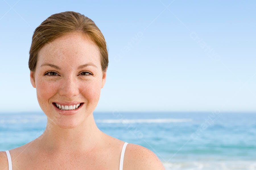 Mulher ruiva feliz na praia