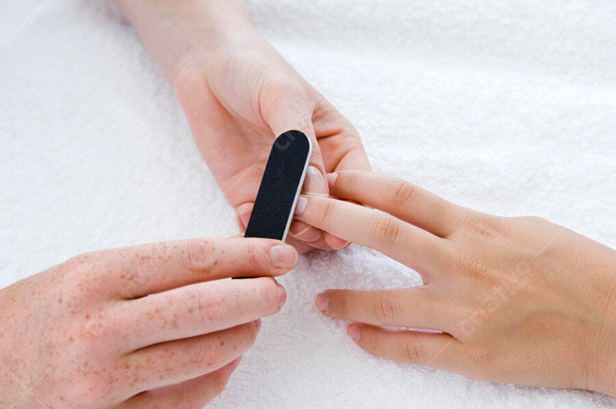 Manicure lixando unhas em salão