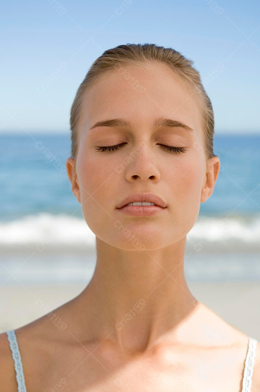Mulher de olhos fechados na praia