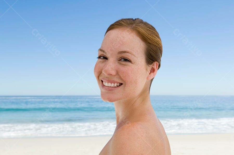 Mulher feliz na praia sorrindo
